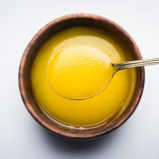 Nutrix Pure Desi Ghee in a wooden bowl with a spoon, showcasing its pure and natural essence.