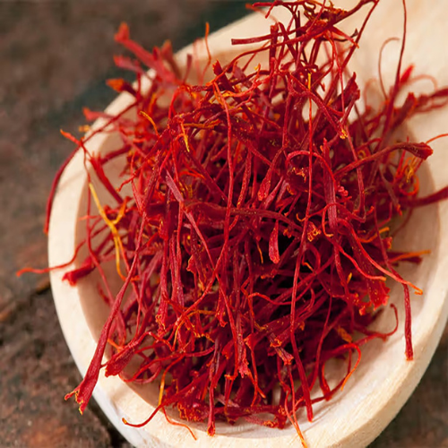 Premium Saffron threads in a wooden spoon showcasing vibrant color and exceptional purity.