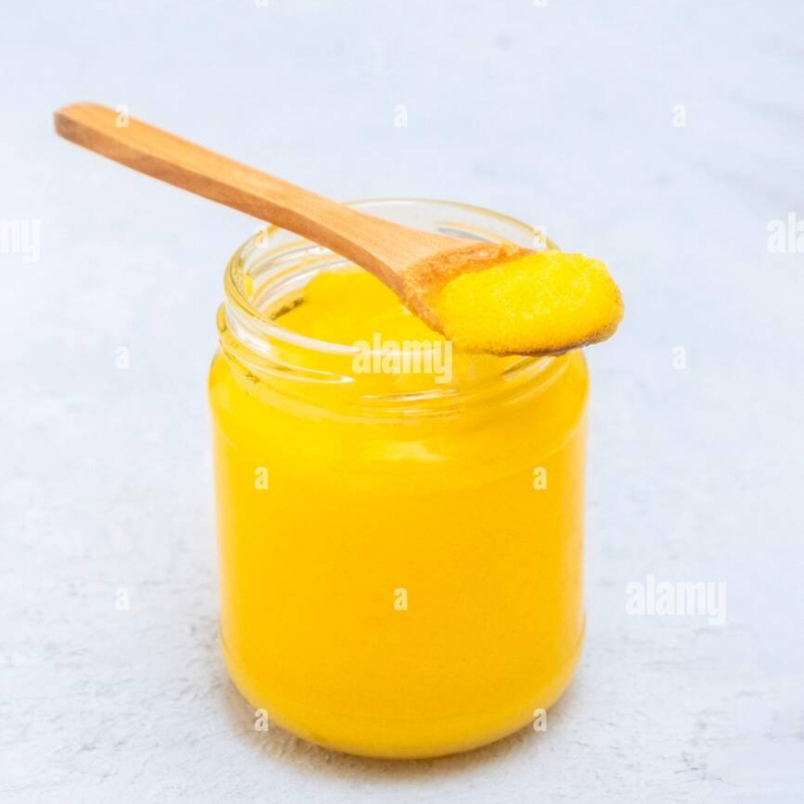 Nutrix Pure Desi Ghee in a jar with a wooden spoon, showcasing its rich yellow color and natural goodness.